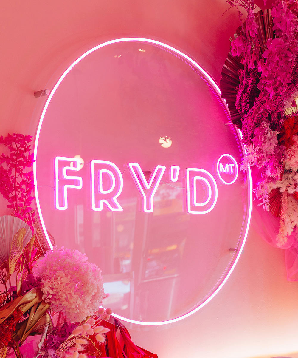 Vibrant neon sign for "FRY'D" on pink backdrop